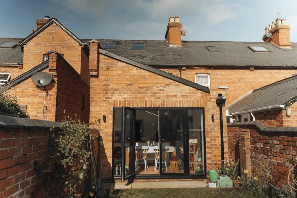 Brick rear extension with black-framed bifold doors opening onto the garden